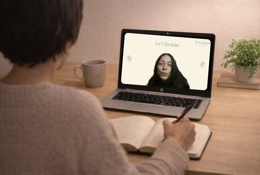 Femme assise à un bureau prenant des notes face à un ordinateur affichant une vidéo du programme Le Chemin.