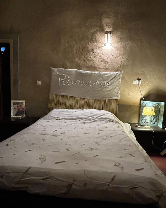 Chambre du gîte avec lit double, lampe douce et ambiance chaleureuse.